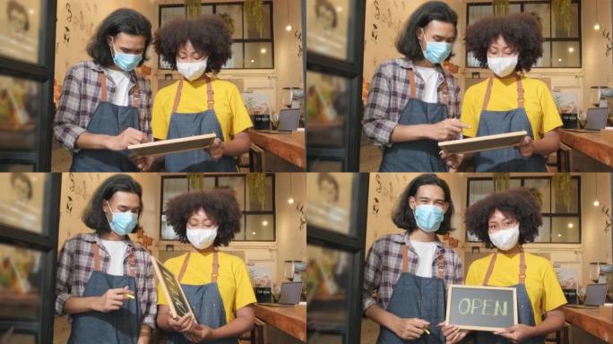 Two baristas with face masks show an open sign, a 