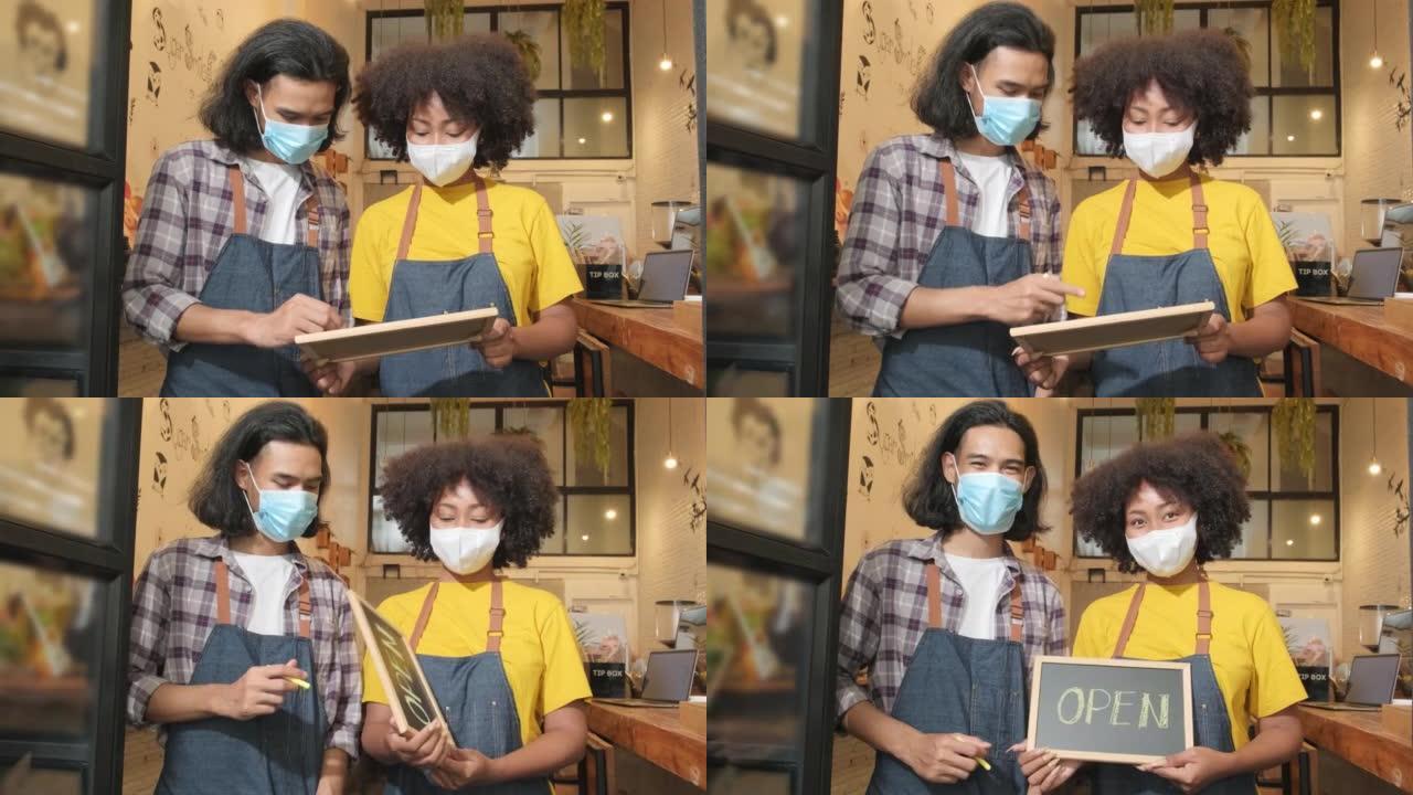 Two baristas with face masks show an open sign, a 