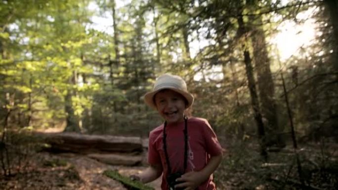 日落时在树林里笑的小男孩