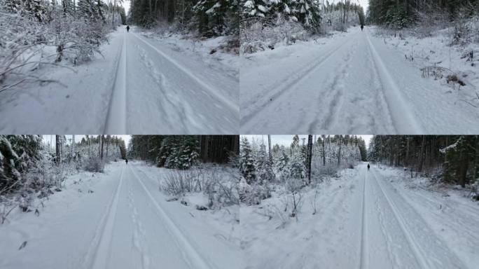 空中无人机拍摄了一名妇女在树林中沿雪道行走的镜头