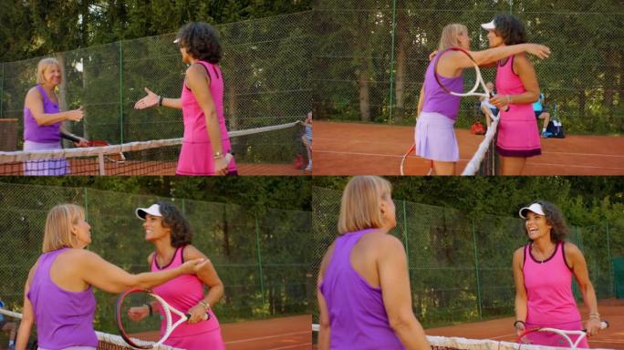 SLO MO两名女子在外面的网球场打单打后握手拥抱