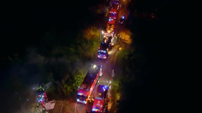 一群消防员夜间灭火的无人机飞行视点。英雄准备拯救危机中的人们