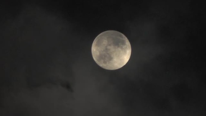 云中的月亮。夜空之谜。云在月亮前面飞快。远摄变焦
