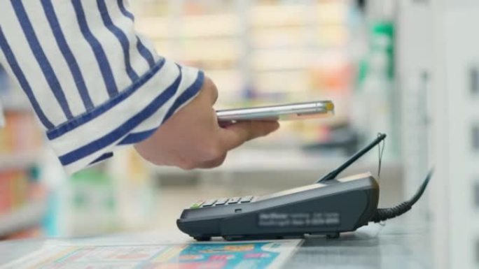 超市收银员女子拿着电话扫描付款