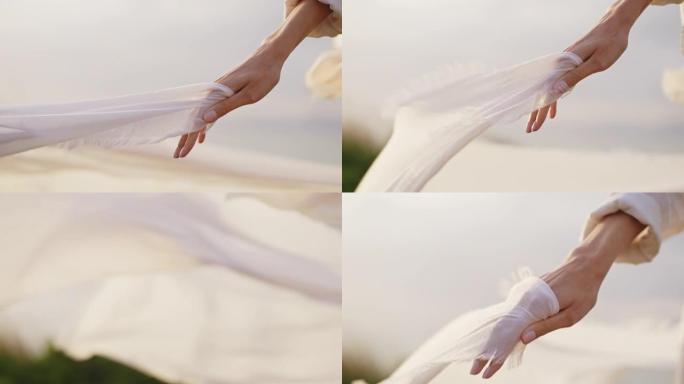 特写手神秘女子手持透明白色面纱在风中挥舞
