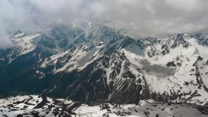 空中飞行穿过山云，飞越美丽的白雪皑皑的山峰和冰川。