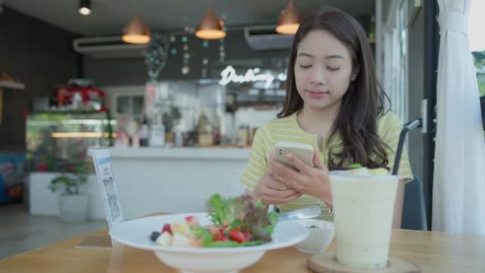 美女在咖啡馆用智能手机扫二维码。这家餐厅建立了一个没有现金的数字支付系统。二维码支付，E钱包，现金技