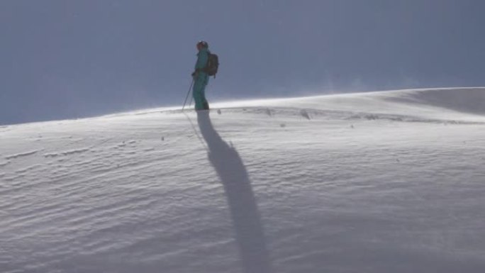 孤独的滑雪者站在雪山上飘雪