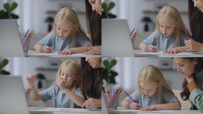 一个年轻的女人，一个母亲或一个保姆和一个女孩一起用铅笔画一幅画。有爱心的妈妈或保姆教女孩画画
