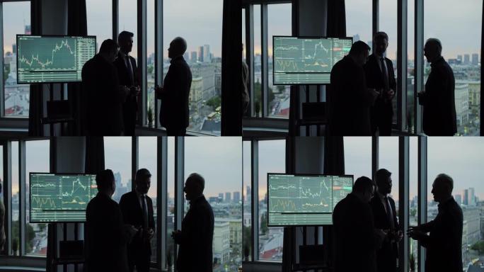 摩天大楼窗户上的商人剪影。股市交易分析在屏幕上