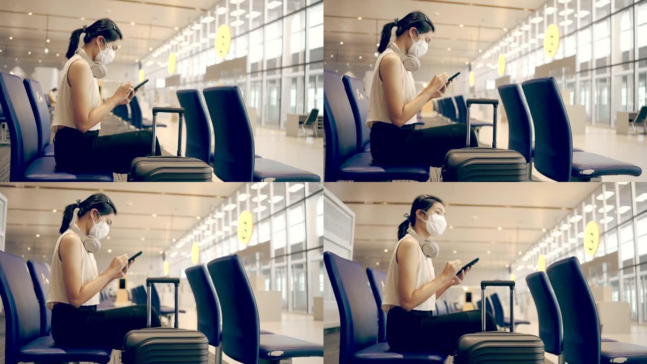 女乘客在登机时播放等候的平板电脑。在出发航站楼