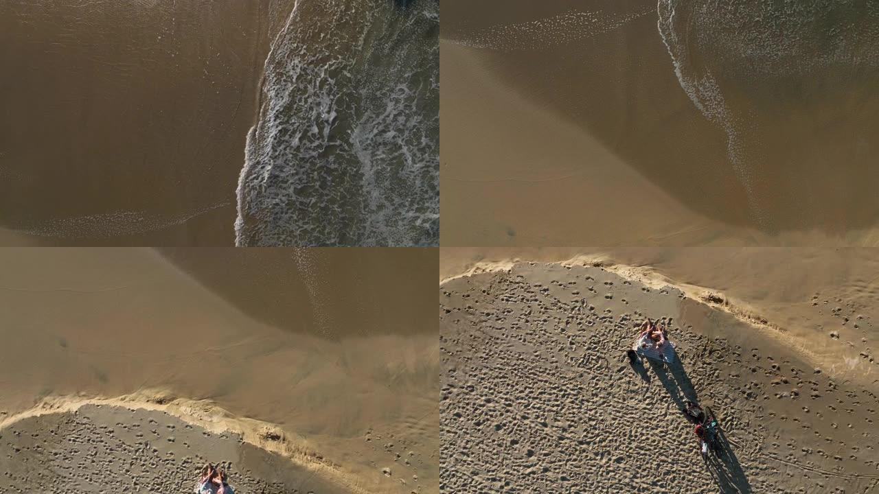 夫妇在海滩上放松的鸟瞰图，骑自行车