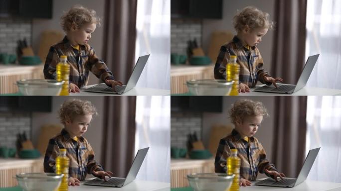 现代儿童正在使用带互联网的笔记本电脑，小男孩正在按下键盘上的按钮并在屏幕上查看
