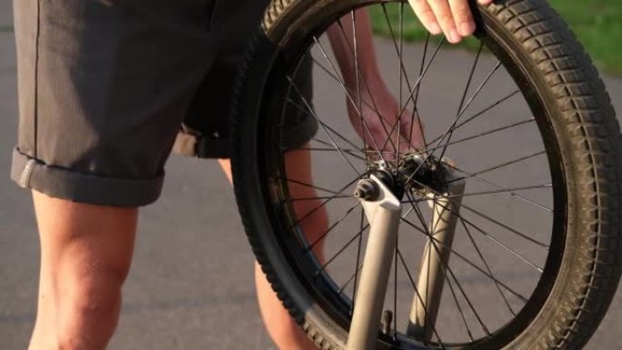 一个人用扳手拧开自行车上的轮子。