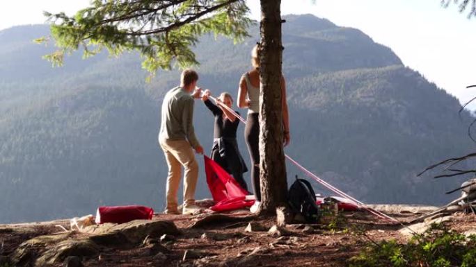 年轻人在山谷上方的岩石板上享受露营经验