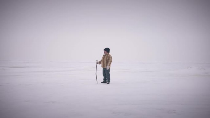 极度宽幅射击快乐自信的高级冒险家站在白色风景如画的极地风景上环顾四周。寒冷的冬日在户外的土著老人。风