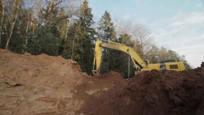 挖掘机在森林的沟渠后挖了一个洞。铺设管道，建设输气的运输公路，工业。
