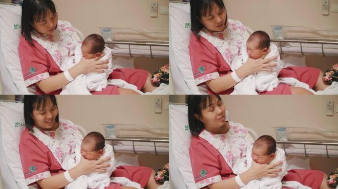 母亲抱着新生男孩 (0-1个月) 在托儿所