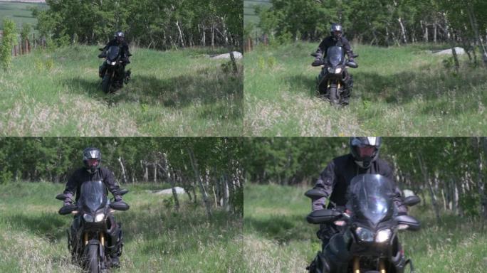 摩托车骑手穿过深草穿过乡村草地