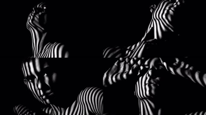 女性的脸和身体在条纹的阴影中。黑白相间的艺术镜头。