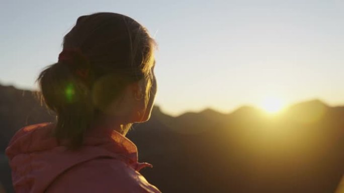 看着山日落的年轻女子。宁静的风景