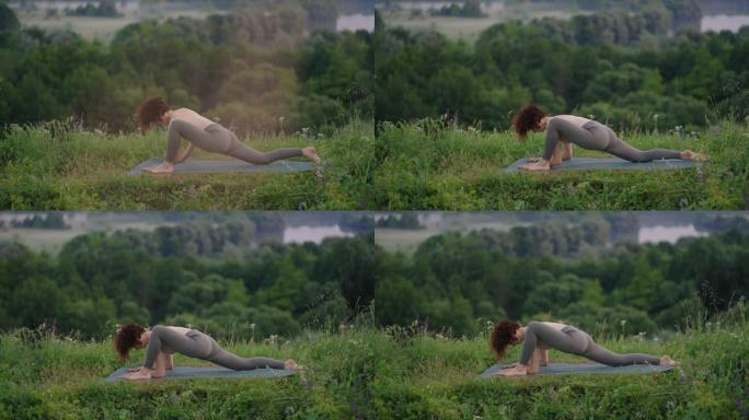 山上的瑜伽冥想。做瑜伽姿势的女孩，日出时在悬崖上进行训练。年轻的运动女子在山顶上冥想，自然中的禅宗瑜