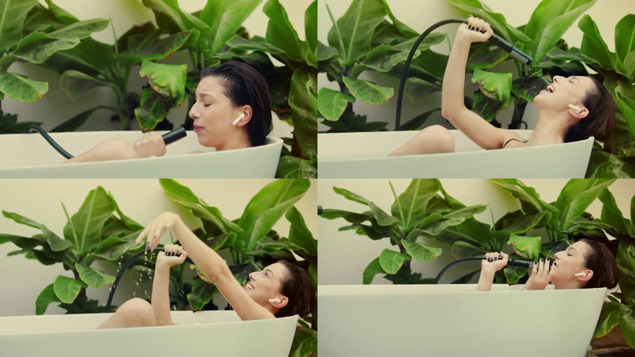 年轻女子在浴室内郁郁葱葱的绿色花园里洗泡泡浴。向手持淋浴唱歌