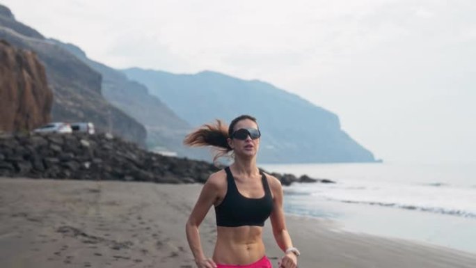 海滨慢跑训练。女人在狂野的海岸线上的剪影