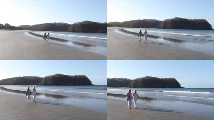 成熟的夫妇沿着空旷的海滩散步，一起聊天