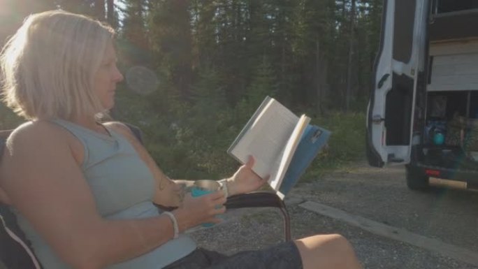 一名妇女在旷野的营地看书的动态镜头