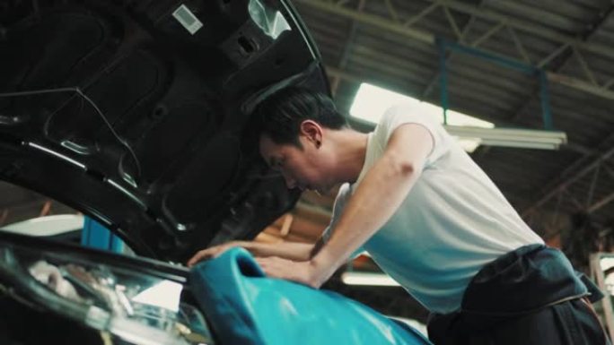 机械师在汽车修理厂检查汽车发动机