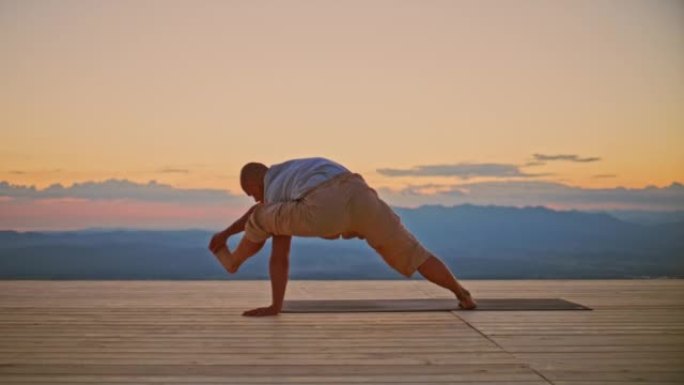 日出时在山顶上瑜伽姿势的SLO MO Man