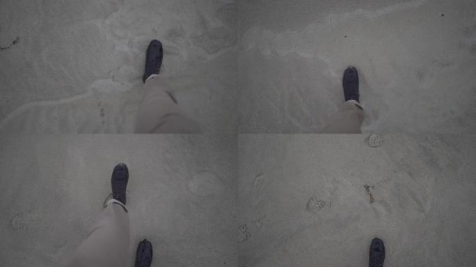 男人的腿在沙滩上行走的POV