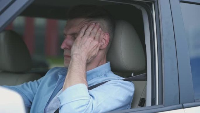 中年男子在开车时感到头痛，偏头痛发作