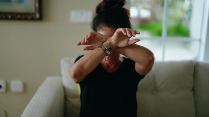 一名西班牙中年妇女双手交叉，示意家中发生家庭暴力