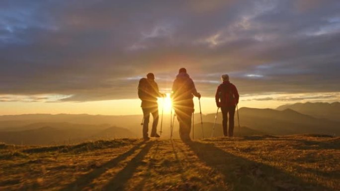 空中SLO MO四名女徒步旅行者在日落时在山顶行走
