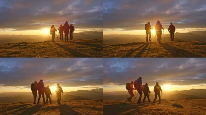 空中SLO MO四名女徒步旅行者在日落时在山顶行走