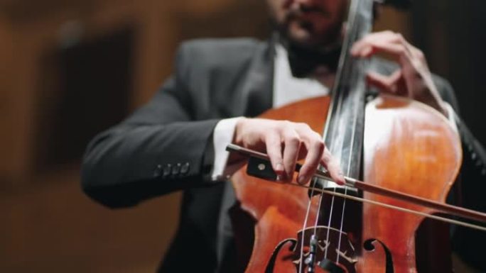 受启发的音乐家正在歌剧院大厅演奏大提琴，排练或古典音乐音乐会，特写镜头