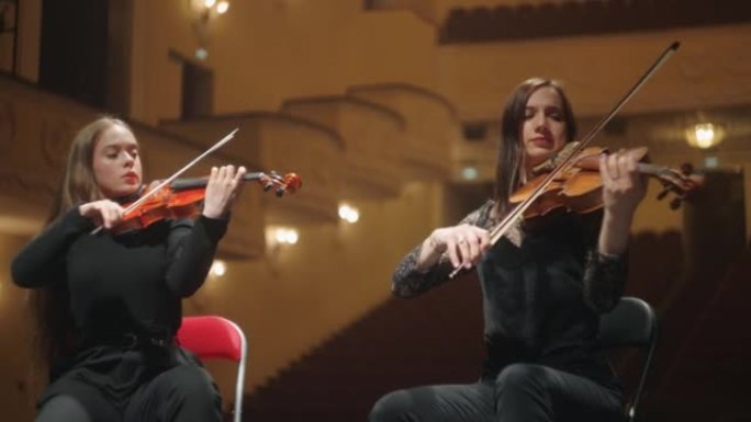 女小提琴手在歌剧院现场演奏音乐，爱乐音乐厅的两位专业音乐家