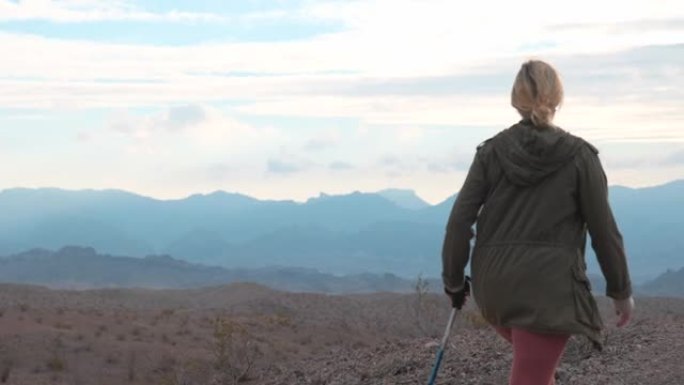 沙漠山脊上的成熟女性徒步旅行者