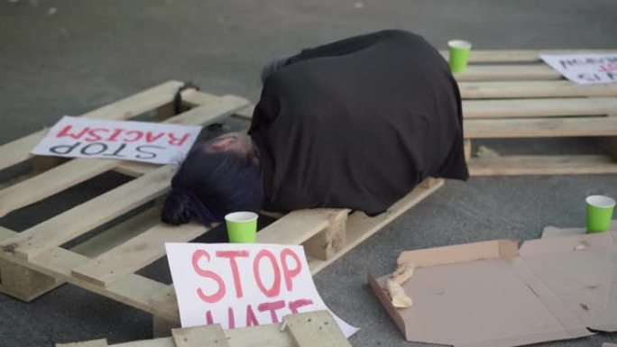 一个年轻女人睡在床上到处都是反种族主义的横幅。女性活动家在人权示威后休息。捍卫民族平等的理念。