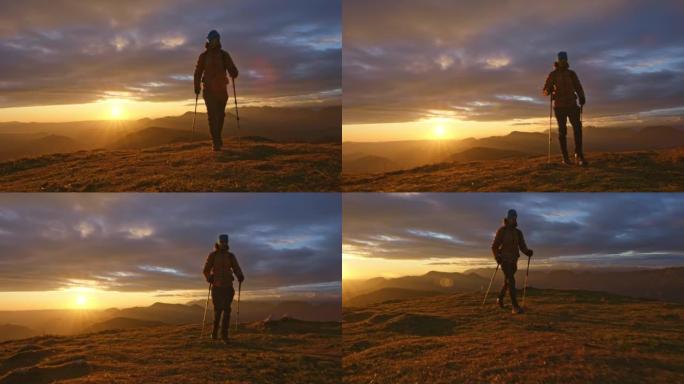 日落时山顶上的空中SLO MO男徒步旅行者