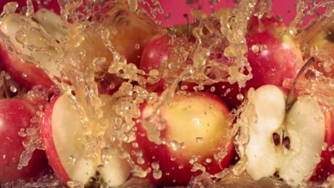 红色苹果汁溅过苹果片的慢动作镜头