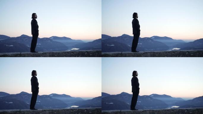 商人站在视点观看日落，欣赏下面的山脉和湖泊