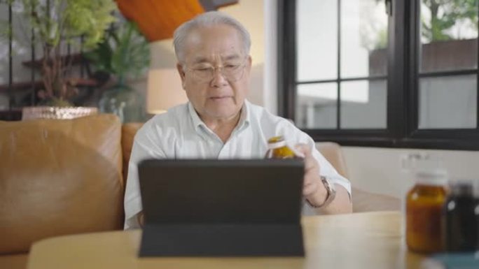 在医生视频咨询中显示药瓶的平板电脑前的高级男子