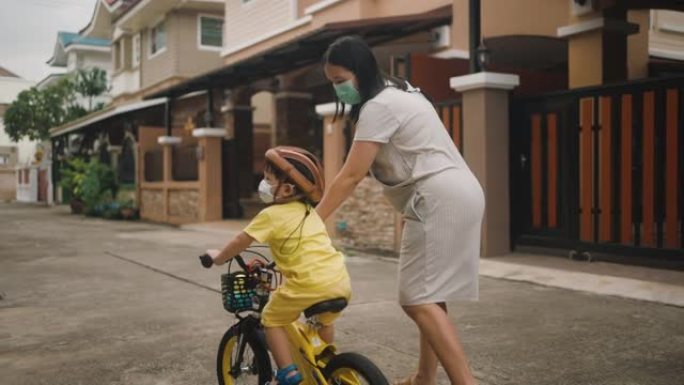 蹒跚学步的小男孩在户外骑自行车玩得开心