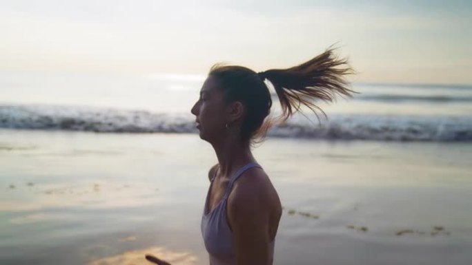 海滨慢跑训练。享受日落和自由的女人。背景中的渡轮