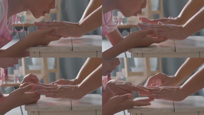亚洲女孩在家为妈妈吹彩绘指甲脚趾，周末水疗概念。