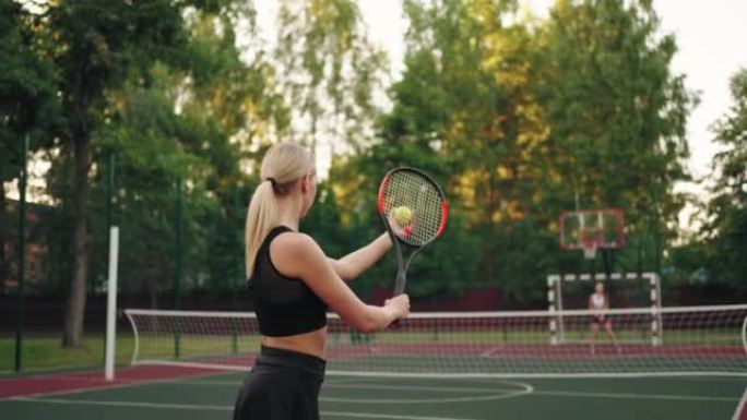 金发女子在球场上发球网球，两名女子网球运动员正在比赛和训练