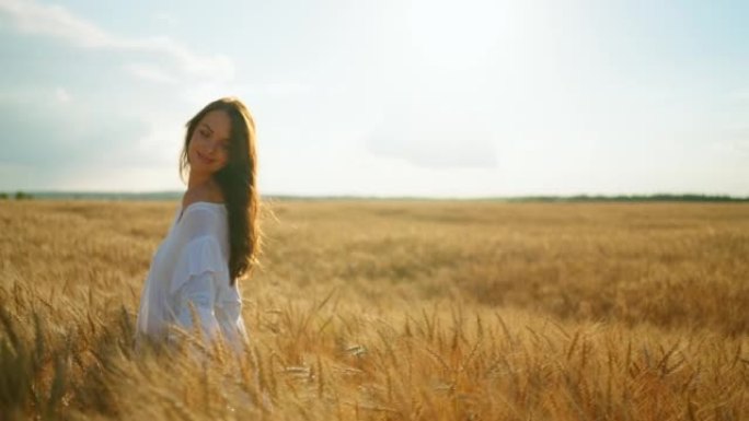 无忧无虑的乡村女人在夏天的金色麦田里玩得很开心，留着长发的漂亮女孩